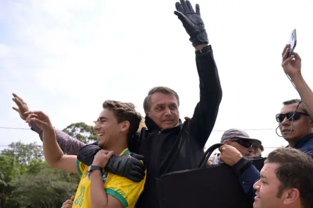 Ferreira durante un acto es abrazado por Jair Bolsonaro.